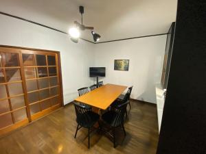 a dining room with a wooden table and chairs at 勝山貸切民泊三つ子の魂 福井県立恐竜博物館まで車で10分 発坂駅から徒歩5分 in Katsuyama