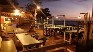 a restaurant with tables and chairs and the ocean at night at kohchang7seaview Bungalows in Ban Bang Bao