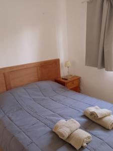 a bedroom with a bed with two towels on it at Departamento del golf in Alta Gracia
