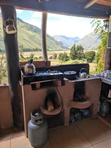 a kitchen with a stove with a view of mountains at Paullo Lodge in Coya +3 photos