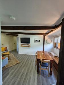 a living room with a wooden table and a tv at The Bullock & Bridle Retreat at 58 in Mintaro