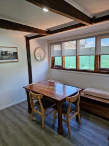 a dining room with a wooden table and two chairs at The Bullock & Bridle Retreat at 58 in Mintaro