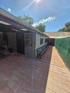a patio with a bench next to a building at The Bullock & Bridle Retreat at 58 in Mintaro