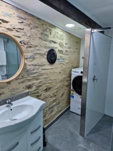 a bathroom with a sink and a washing machine at The Bullock & Bridle Retreat at 58 in Mintaro