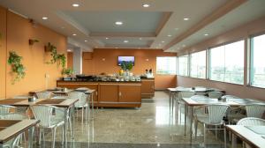 a restaurant with tables and chairs and a counter at Abbas Hotel in Uberlândia
