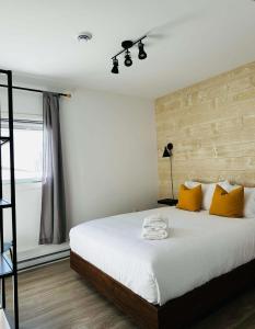 Un dormitorio con una gran cama blanca con almohadas amarillas. en Cottage Quebec - La Zeolite, en Petite-Rivière-Saint-François