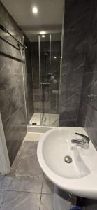 a bathroom with a white sink and a shower at Craven Hotel in London