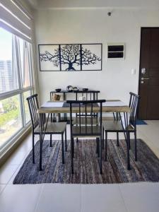 a dining room with a table and chairs on a rug at Cozy, spacious and well lighted condo in Iloilo City