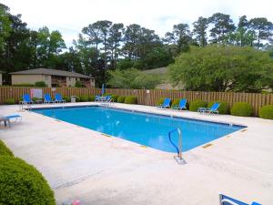 einen Pool mit blauen Stühlen und einem Zaun in der Unterkunft Recreation Central ILM in Wilmington