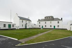 KilbahaLoop Head Lightkeeper's House的一群白色的建筑,有草地庭院