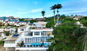 a group of houses on a hill with palm trees at La bardot boutique Pousada in Búzios