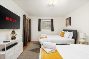 a bedroom with two beds and a tv in it at Pool-GameRoom-HomeTheater-Bar-PlayStructure-FirePit in Oakhurst +109 photos
