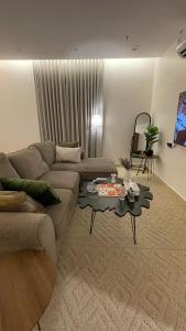 a living room with a couch and a table at استديو فندقي في حي الورود in Al Kharj