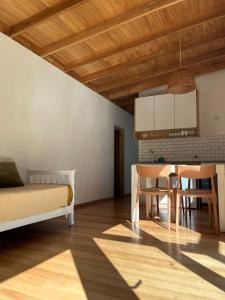 a bedroom with a bed and a kitchen with a table at Casa Los Sauces in Chascomús