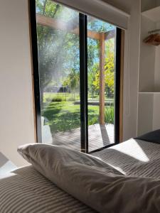 a bedroom with a large window with a view of a yard at Casa Los Sauces in Chascomús