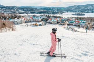 Eine Person steht auf Skiern im Schnee in der Unterkunft Condo moderne, escapade vacance, vue sur montagnes in Mont-Tremblant