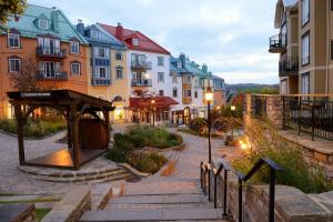 eine Gruppe von Gebäuden in einer Stadt in der Abenddämmerung in der Unterkunft Condo moderne, escapade vacance, vue sur montagnes in Mont-Tremblant