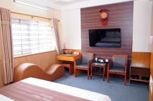 a room with a bed and a desk and a tv at Phuong Anh 3 Hotel in Hai Phong