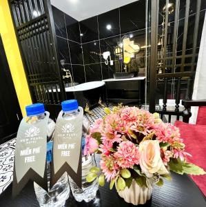 a table with two bottles of milk and a bouquet of flowers at New Pearl Hotel HCM in Ho Chi Minh City