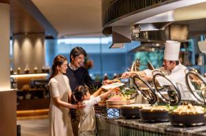 a group of people standing in a kitchen preparing food at ANA InterContinental Tokyo by IHG in Tokyo