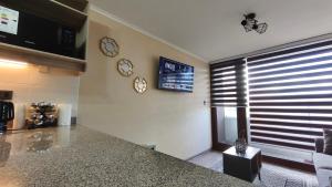 a kitchen with a counter and clocks on the wall at Departamento centro Temuco in Temuco