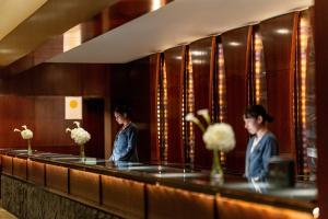 two women standing at a counter in a hotel lobby at ANA InterContinental Tokyo by IHG in Tokyo