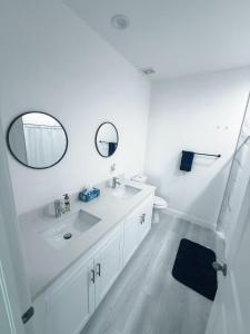 un bagno bianco con lavandino e specchio di Casa compartida vacacional a La Belle