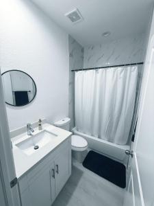 un bagno con lavandino, WC e specchio di Casa compartida vacacional a La Belle