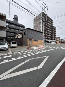 Una calle vacía con coches aparcados en un estacionamiento en みんなの宿Kumamoto, en Kumamoto 3 fotos más