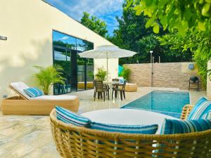 a patio with chairs and an umbrella and a pool at Villa Paz CASA QUINTA CON PISCINA PRIVADA in Ricaurte