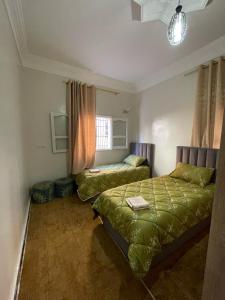 a bedroom with two beds and a couch in it at relax au cœur de la ville in Taroudant