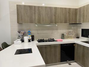 a kitchen with white counter tops and wooden cabinets at Ocean Blue Homestay in Fan-shu-liao