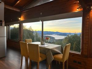 a dining room with a table and a large window at Cabaña de montaña en Cerro Otto con increible Vista al Lago in San Carlos de Bariloche