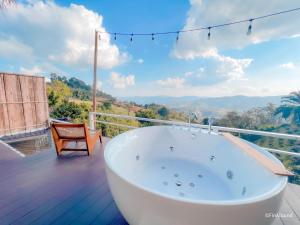a bath tub on a deck with a view at Bella Lunar Villa ดอยแม่สลอง in Mae Salong