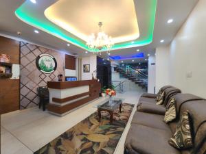 a lobby with a couch and a table and stairs at The Cedar Vatika Hotel and Restaurant in Dharamshala