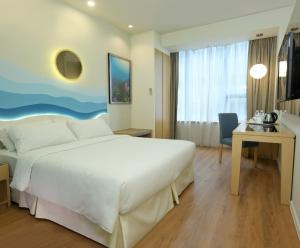 a hotel room with a large bed and a desk at Oceania Hotel in Kota Kinabalu