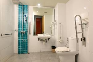 a bathroom with a toilet and a sink and a shower at Oceania Hotel in Kota Kinabalu +19 photos