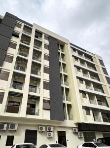 a building with cars parked in front of it at Modern Apartment in Boshar, Muscat in Muscat