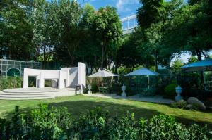 a white building with umbrellas in a yard at Royal Grace Hotel Optics Valley Wuhan in Wuhan