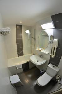 un bagno con lavandino, WC e specchio di Hotel Mira-Mar a Valras-Plage