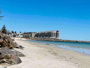 a sandy beach with buildings in the background at Beach apartment 22 esplanade sea-views in Glenelg