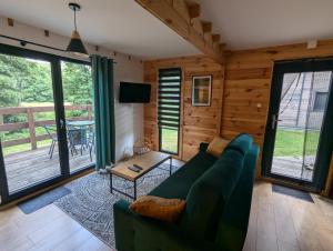a living room with a couch and a table at Dom wakacyjny i Domki letniskowe nad Tanwią Roztocze in Narol
