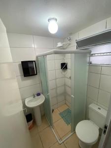a bathroom with a shower and a toilet and a sink at Paraíso Montanha e Mar in Peruíbe
