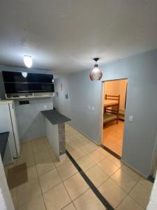 a kitchen with a counter and a table in a room at Paraíso Montanha e Mar in Peruíbe