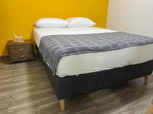 a bedroom with a bed and a nightstand with a bed sidx sidx at Casa Vittoria in Cali +7 photos