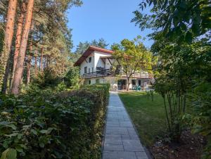 a house with a garden and a walkway at Dom wakacyjny i Domki letniskowe nad Tanwią Roztocze in Narol