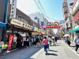 a group of people walking down a busy city street at 池袋House3F Cozy for 1-3 guests in Tokyo
