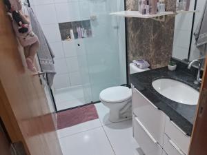 Un baño con lavabo, inodoro y ducha. en Quarto da Tay, en Paranavaí