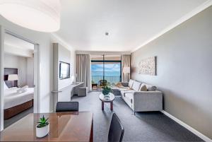 un soggiorno con un divano e un tavolo di Two Private Oceanview Suites with Resort Pool a Darwin