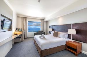 una camera d'albergo con un letto grande e una scrivania di Two Private Oceanview Suites with Resort Pool a Darwin